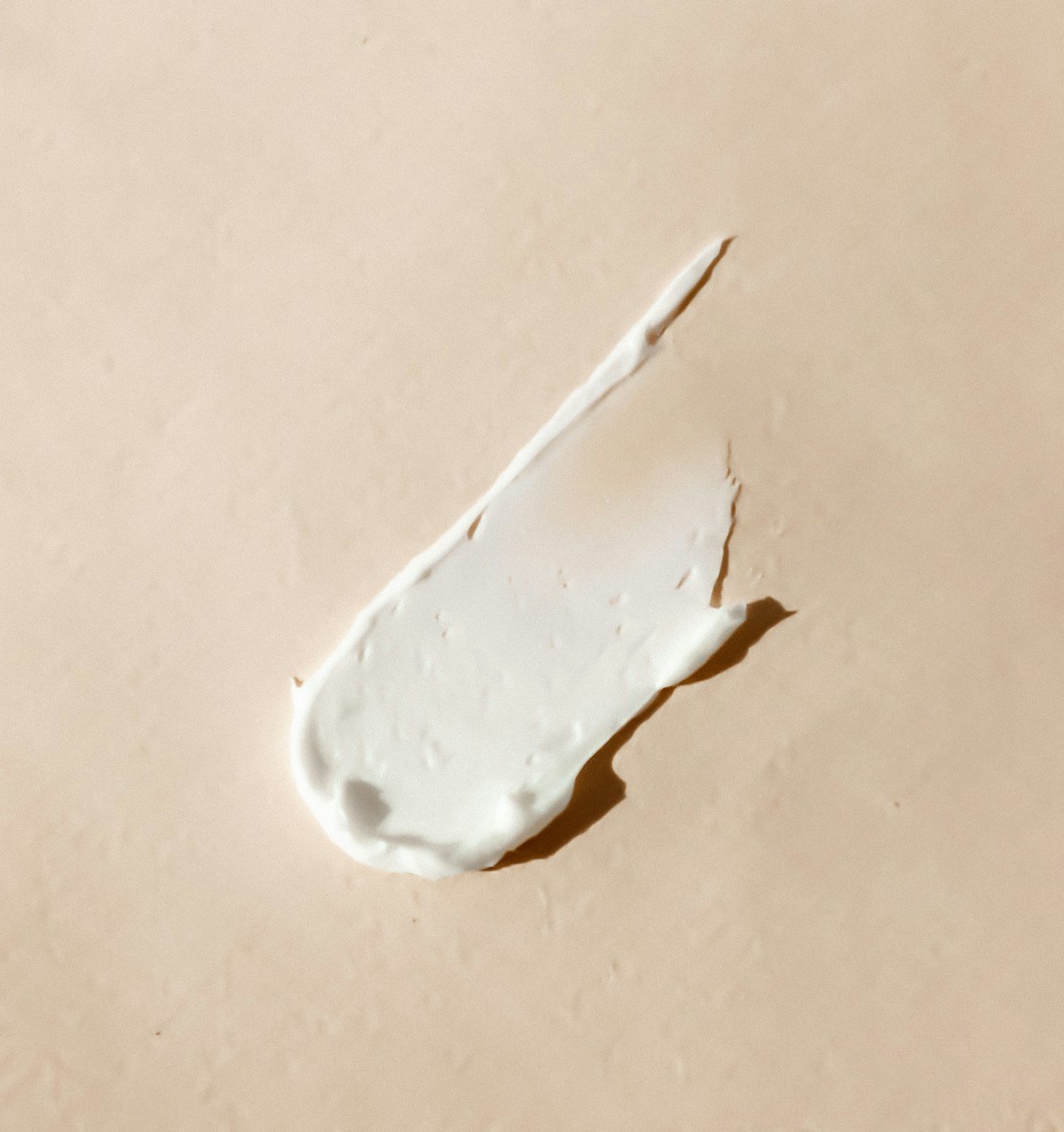 Textura de creme sobre superfície clara, referência aos protocolos faciais